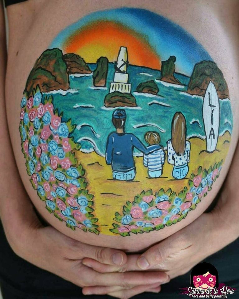 Bellypaint de un paisaje de playa con faro y una familia